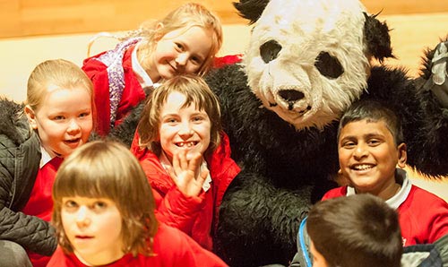 Children in primary school with someone in a panda costume