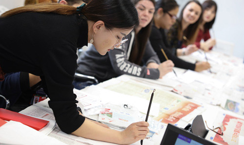 A photograph of a tutor teaching Chinese calligraphy